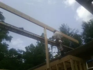 Carpenter setting a ridge beam over a new addition frame — Ice Dam Removal by Roofing Brothers in Wilmont