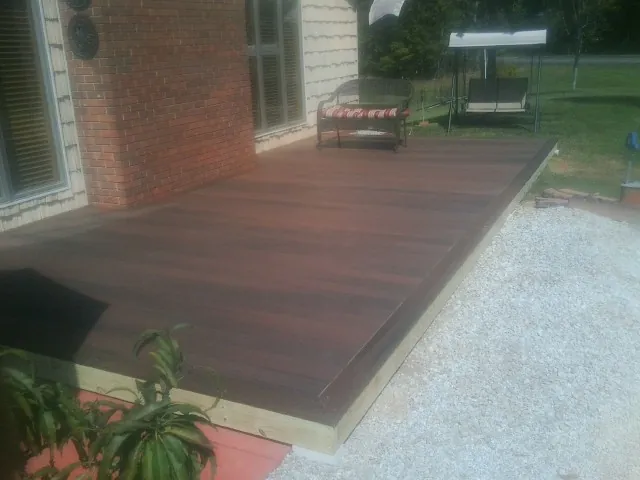 Freshly stained wood deck built against a brick home in Wilmont