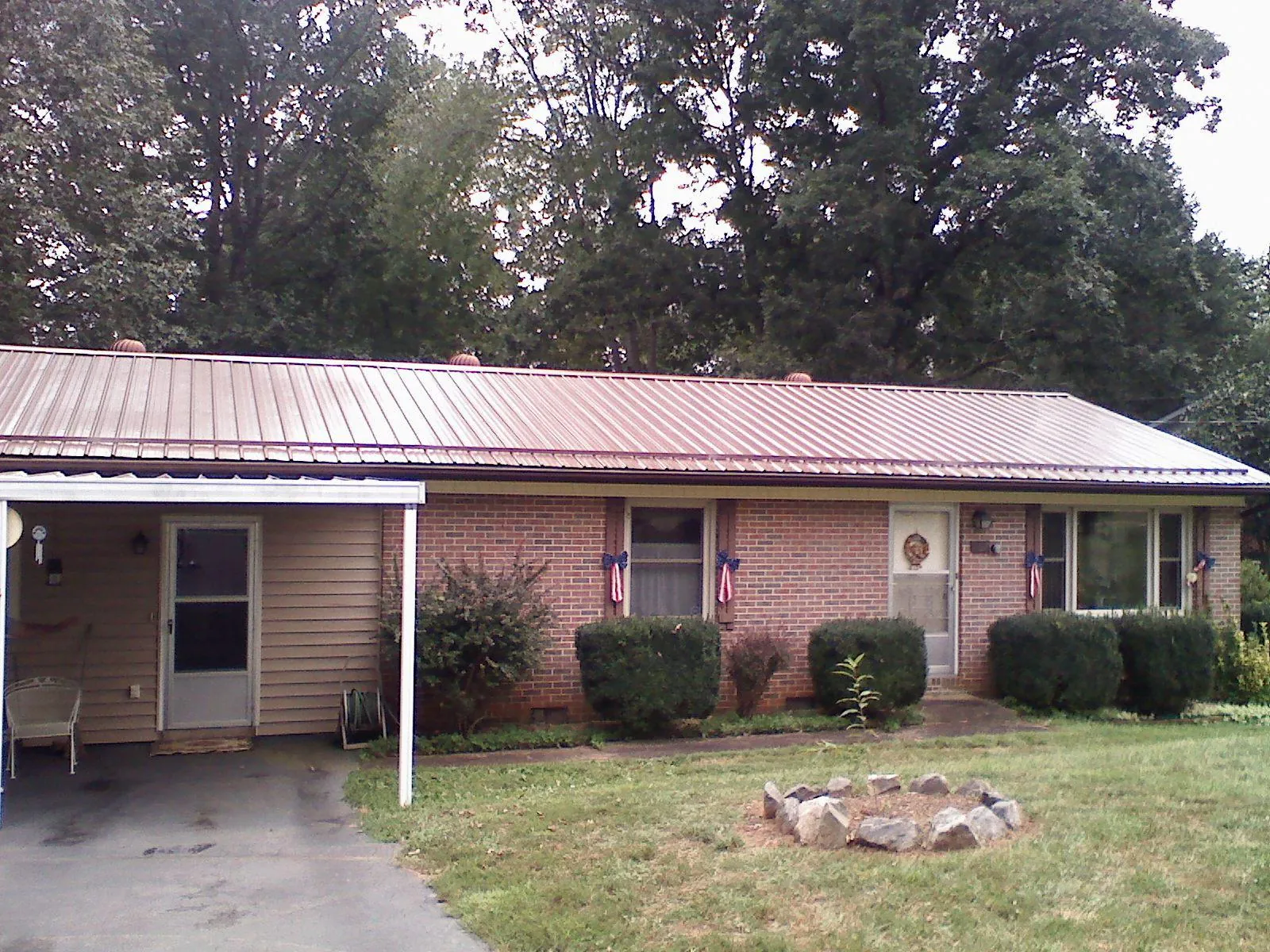Bronze metal roof and carport on a brick ranch home — Roof Repair work by our crew in Wilmont