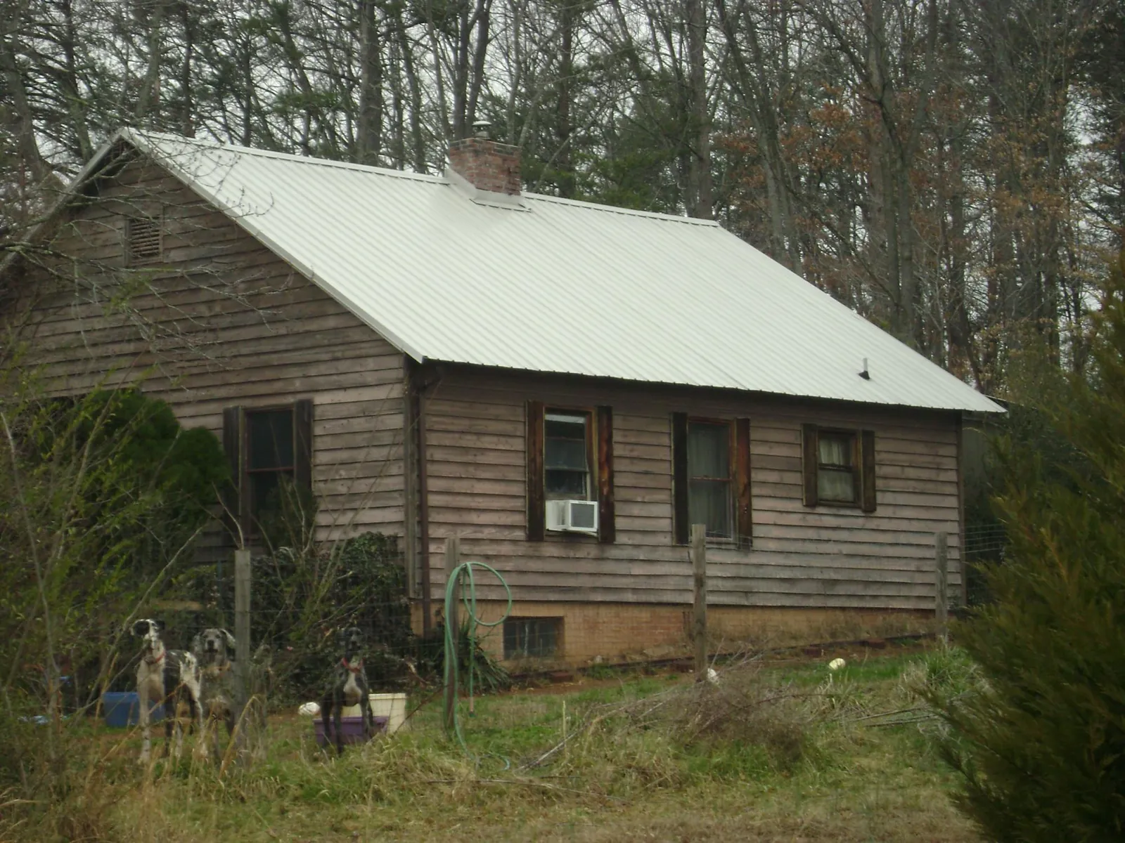 White metal roof on an old wood sided farmhouse, from a Metal Roof Installation job in Wilmont